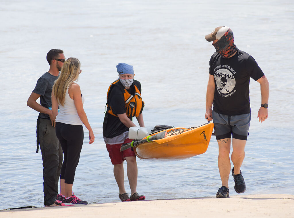 Volunteers Matthew Hall and Nick Hergott carry a kayak up the boat ramp